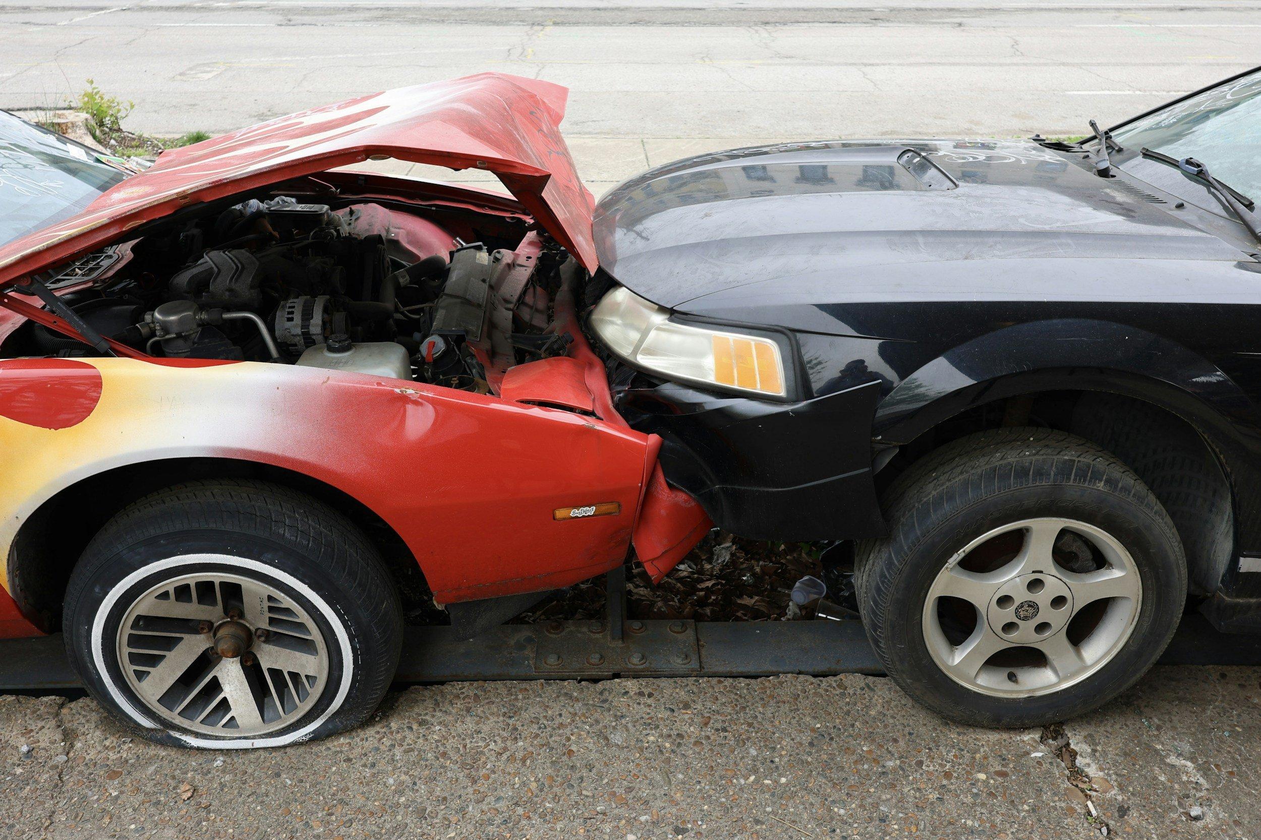 A car accident showing two cars collided head-on, with visible front-end damage on both vehicles.
